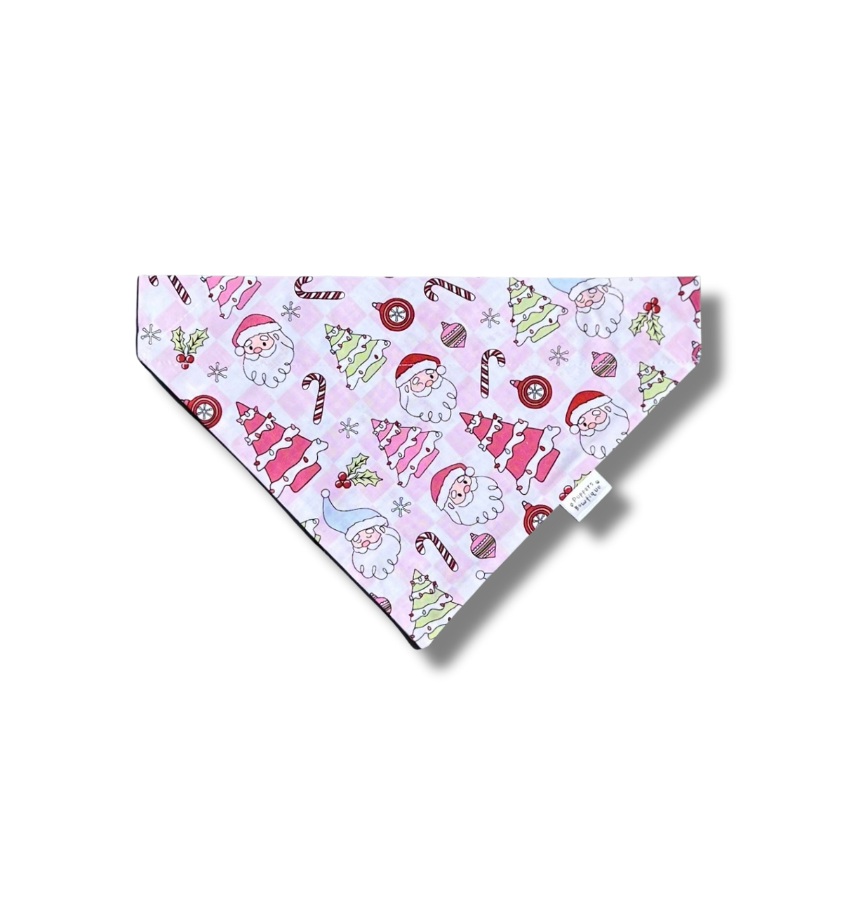 A triangular pet bandana featuring a festive Christmas print with Santa Claus, candy canes, ornaments, and snowflakes on a light pink background, displayed on a clean white background with a soft drop shadow.